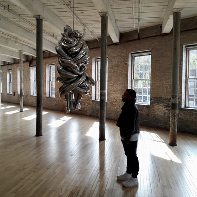 Anulfo Baez engrossed in Louise Bourgeois's sculpture, The Couple.